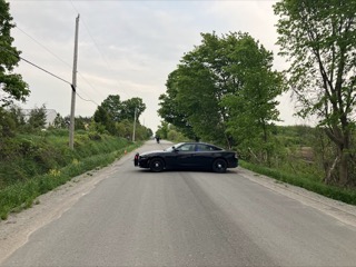 Black police cruiser on a rural road