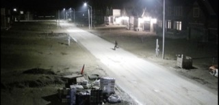 Empty street at night, lit by streetlights.