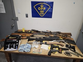 Firearms and Canadian currency on a table.