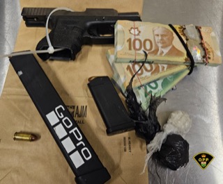 Firearm, magazines, ammunition, Canadian currency, and a GoPro camera on a brown surface.
