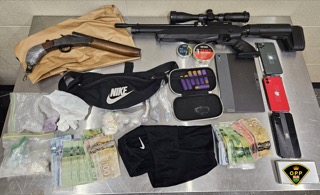 Air rifle with scope, money bundles, and a black Nike drawstring bag.