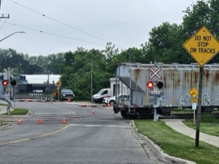 Railroad crossing with a truck blocking the tracks.