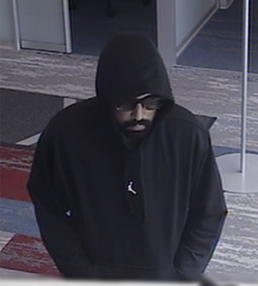 Person in a black hoodie and sunglasses