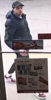 Man in black puffer jacket and baseball cap