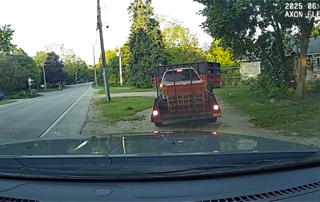 Red pickup truck driving on a residential street