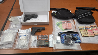 Firearm in a box, cash, scales, and plastic bags.