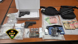 Firearm in a box, cash bundles, digital scale, and bags on a surface
