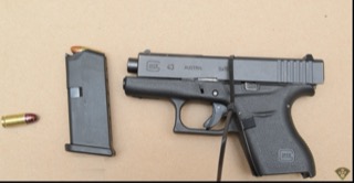 Glock pistol and magazine on a surface.
