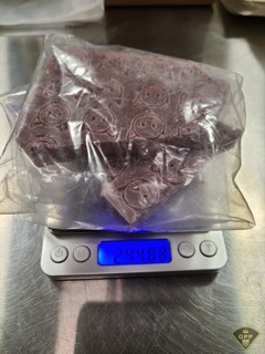 Dark brown substance on a scale, reading 24.48