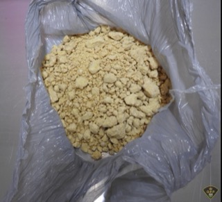 Pile of yellowish-brown crystals in a plastic bag