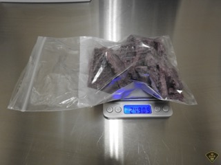 Purple crystals in a clear plastic bag on a scale that reads 2.4909