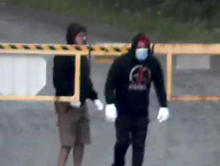 Two people wearing masks and gloves.