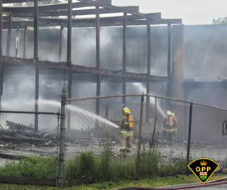 Firefighters spray water on a burned building.