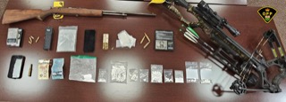 Firearm, bow, and packages of drugs and cash.