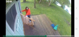 Person descending wooden stairs, wearing a red jacket and white shoes