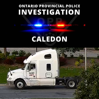 White semi-truck with flashing blue and red lights.