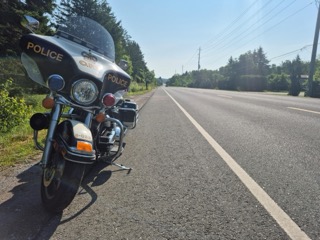 Police motorcycle parked on the side of a road.