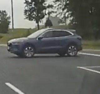 Blue SUV driving on a road