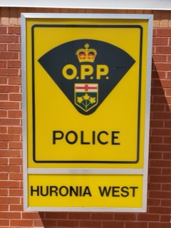 OPP crest on yellow sign POLICE HURONIA WEST