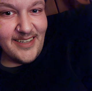 Smiling man with a mustache and nose ring