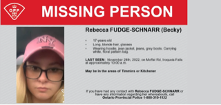 Missing person poster. Rebecca Fudge-Schnarr, 17, long blonde hair, glasses, wearing a hoodie, jean jacket, jeans, grey boots, carrying a white floral pattern bag. Last seen November 24th, 2022, on Moffat Rd, Iroquois Falls, approximately 10:00 a.m. May be in the areas of Timmins or Kitchener.