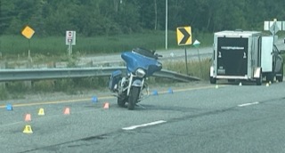 Motorcycle on the side of a highway, traffic cones visible