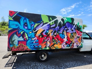 Colorful graffiti covers a white box truck.