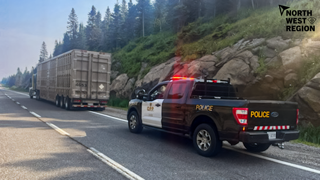 Police truck and semi-truck on a highway.