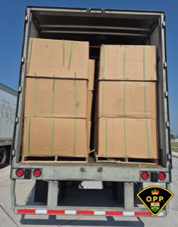 Stacked cardboard boxes on pallets inside a truck.