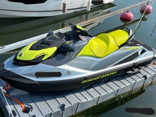 SeaDoo jet ski, green and black, on a floating dock
