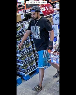 Man wearing a black t-shirt that says "New York" and blue denim shorts.