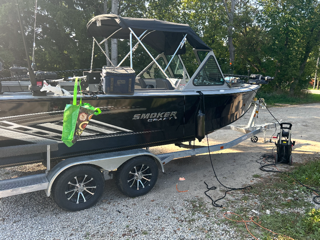 Black aluminum fishing boat on a trailer.