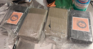 Three yellow and orange wallets stacked on a surface.