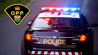 O.P.P. crest, black Ford police vehicle, flashing red and blue lights