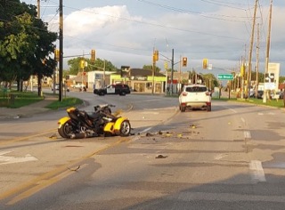 Damaged trike on the street, police car and white SUV nearby