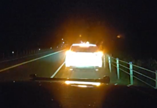 Bright headlights approaching on a dark road