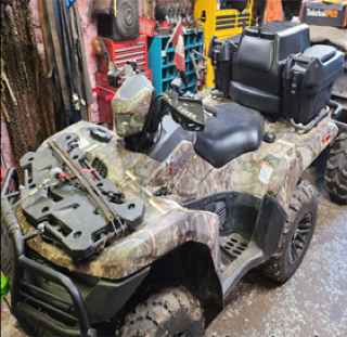 Mud-covered four-wheeler with a camouflage pattern