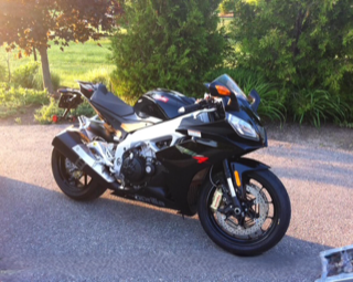 Black Aprilia motorcycle parked on pavement