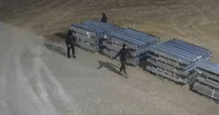 Blue stadium bleachers, two people walking by