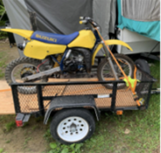 Yellow and blue dirt bike on a black utility trailer