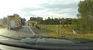 Fire truck and emergency personnel on a roadside.