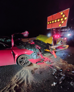 Damaged pink car and traffic signal.