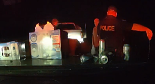 Toy police officer and laundry items on a dark surface.