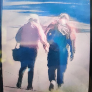 Two people walking and holding hands.