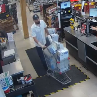 Employee pushing a cart of cleaning supplies.