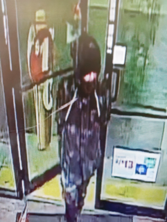 Person wearing a dark hoodie and jeans, viewed from behind.