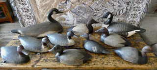 A group of carved duck decoys on a wooden table