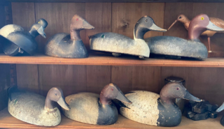 Wooden duck decoys on shelves