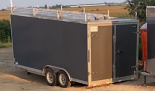 Black utility trailer with dual wheels.