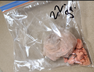 Brown clay and red coral in a plastic bag